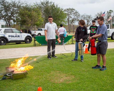 Fire and Life Safety Inspector, Daniel Cardona (left) teaching FGCU students how to safely use fire extinguishers on the library lawn on Jan. 26, 2023.