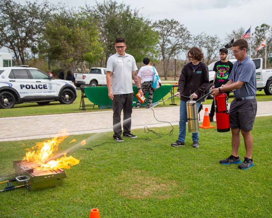 Fire and Life Safety Inspector, Daniel Cardona (left) teaching FGCU students how to safely use fire extinguishers on the library lawn on Jan. 26, 2023.