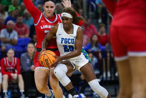 Sha Carter (20) drives to the basket against Liberty in the ASUN Championship