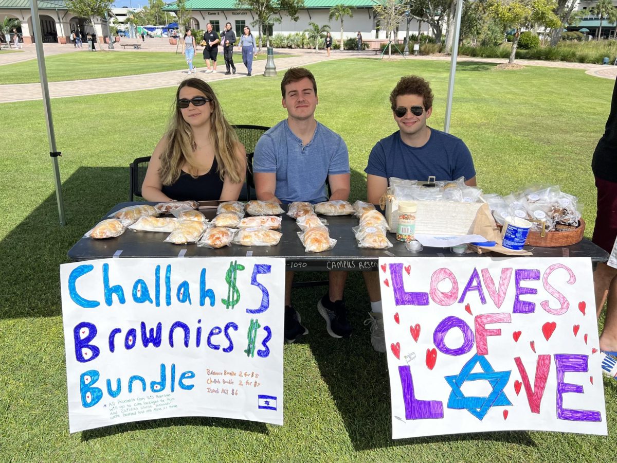 
FGCU Alpha Epsilon Pi (AEII) and Chabad of FGCU set up a table with baked goods on the library lawn