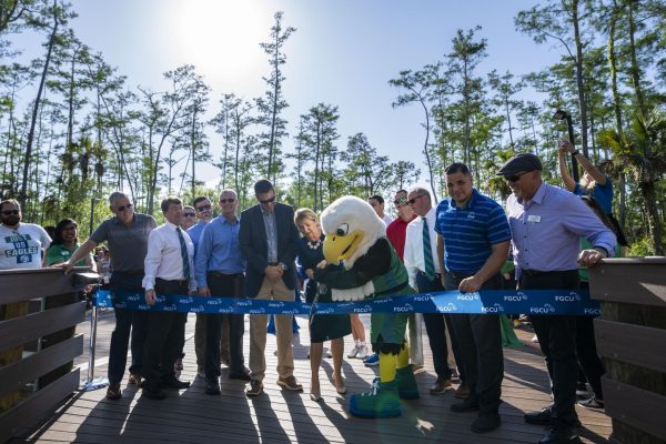 President Timur and Azul the Eagle cut the ribbon across the new boardwalk connecting the South Village dorms to main campus during the opening celebration on Thursday, April 18, 2024. Photo by Jessica Piland/FGCU Marketing & Communications. 